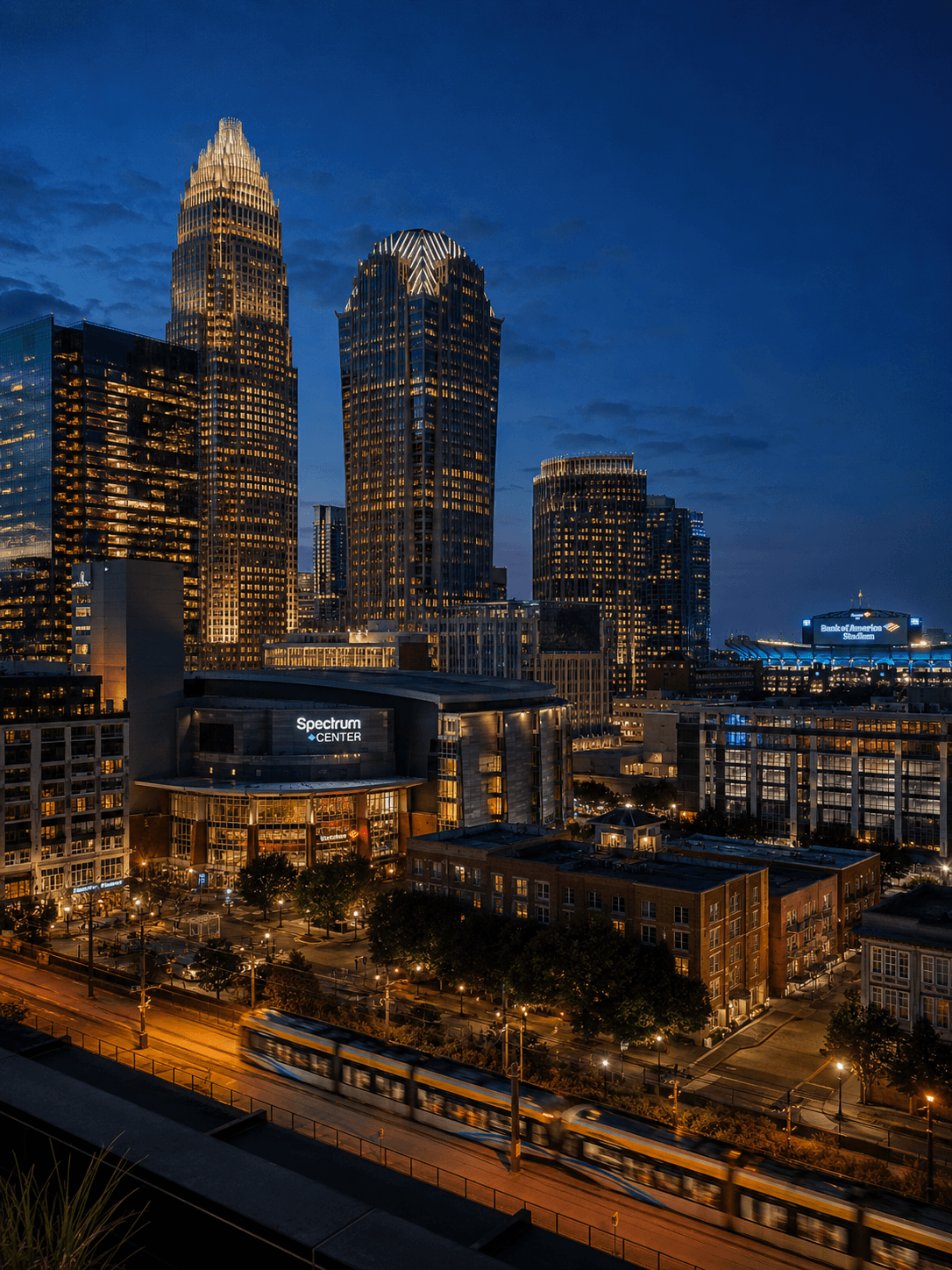 The Spectrum Center and Uptown Charlotte skyline at blue hour, a Gold Line streetcar passing in the foreground.